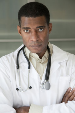 Black doctor in lab coat with arms crossed