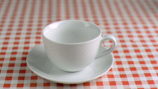 Tea bag falling in super slow motion in a cup