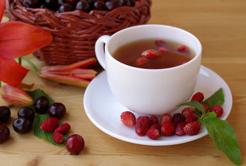 Tea with ripe strawberries and cherry