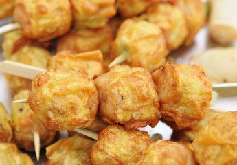 Thai dough stuffed with meat on wooden sticks
