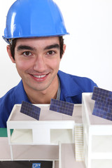 portrait of young bricklayer posing near model