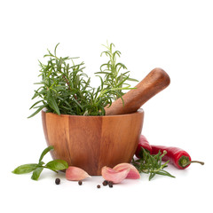 fresh flavoring herbs and spices in wooden mortar