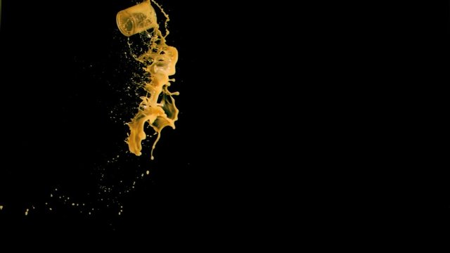 Orange juice glass thrown in super slow motion