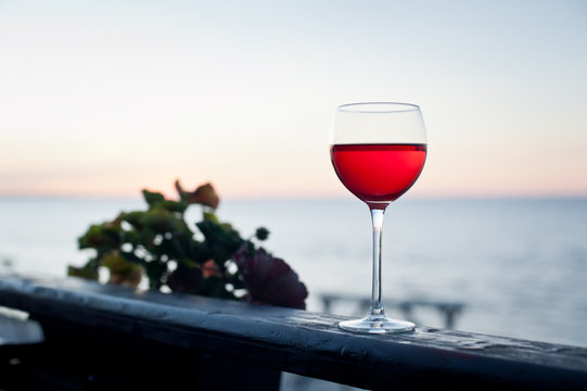 A glass of red wine at sunset on terrace