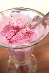 Pink ice cream in glass bowl, closeup