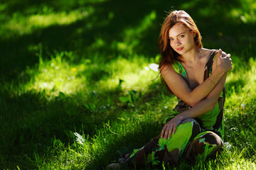 brunette sitting on green grass