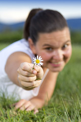 Cute smiling girl with a daisy