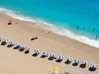 people on the sea beach with sunbeds and umbrellas
