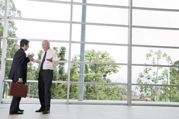 Hispanic businessmen talking together in lobby