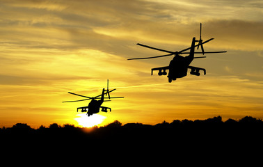 Helikoptersilhouetten op zonsondergangachtergrond