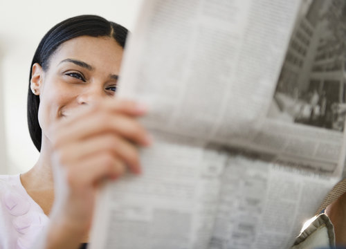 African American woman reading newspaper