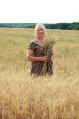 Naklejka na ściany i meble portrait of an elderly woman in a wheat field