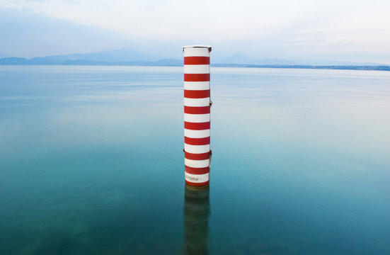 Red and white stripe pillar in tranquil lake