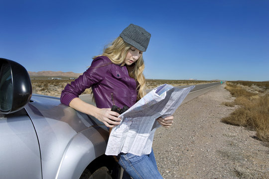 Caucasian woman reading map at roadside