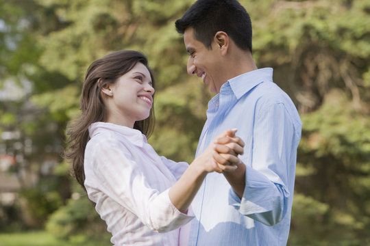 Hispanic couple dancing together outdoors