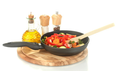 frying pan with vegetables on white