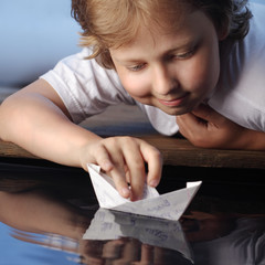 Naklejka premium paper ship in children hand