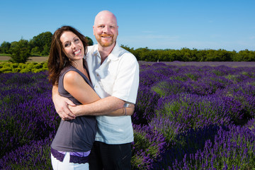 Happy middled aged couple in a field of purple lavender