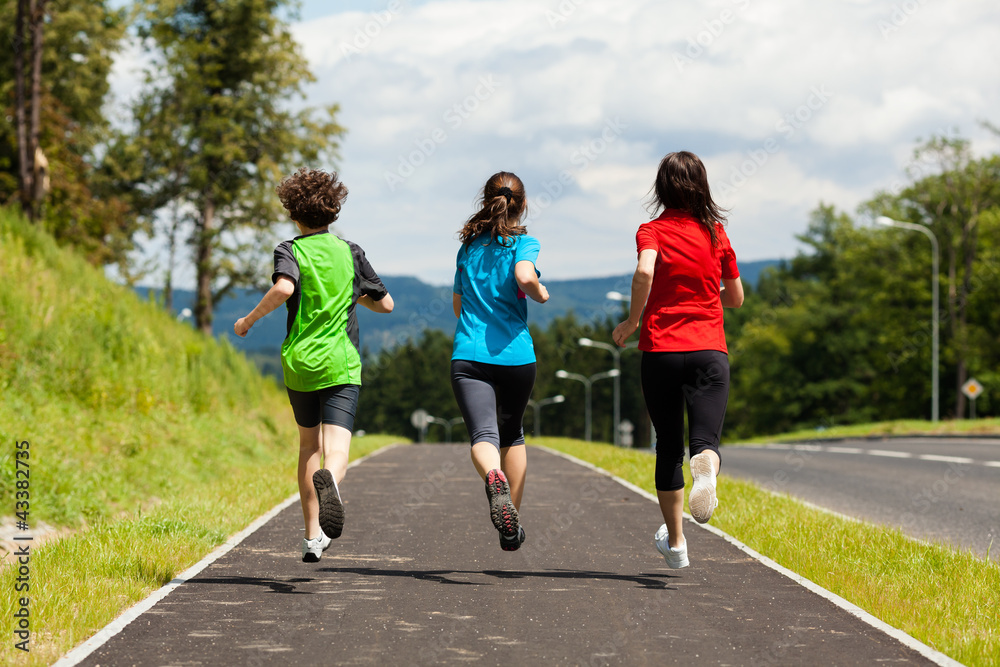 Wall mural Active family - mother and kids running outdoor