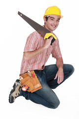 carpenter with saw kneeling