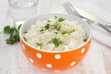 boiled rice in orange bowl with parsley