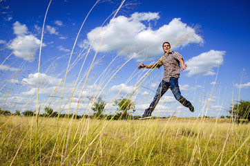 Young man jumping on dry meadow