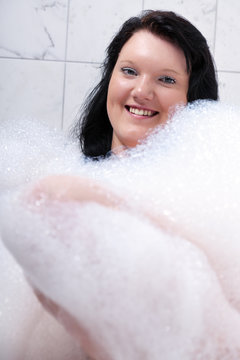Young woman has fun in the bathtub