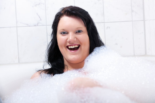 Young woman has fun in the bathtub