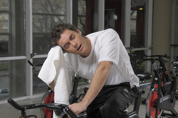 Obraz premium Hombre joven haciendo gimnasia en bicicleta