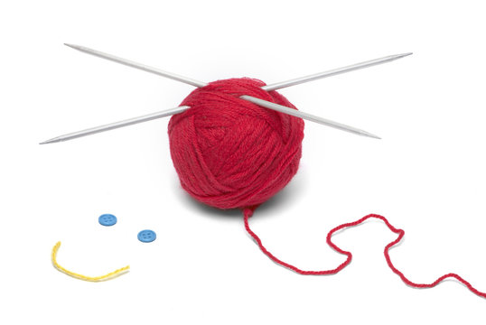Red ball of wool with knitting needles and smiley