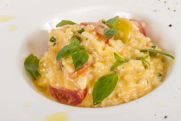 photo of delicious risotto dish with herbs and tomato on white b