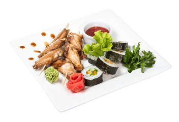 Buffalo chicken wings on plate with sushi