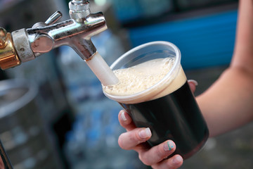 Fototapeta na wymiar Festiwal Beer wylewanie ciemnego piwa do szkła