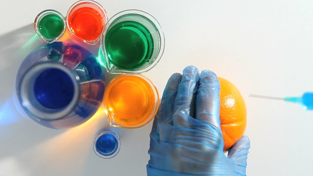 Chemist placing a blue liquid in an orange