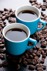 Close-up of two espresso cups and coffee beans