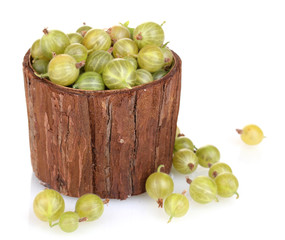 Green gooseberry in wooden cup isolated on white