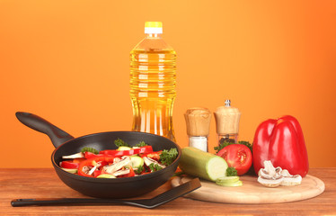 frying pan with vegetables on red background