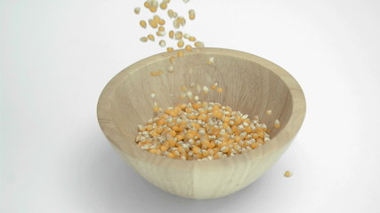 Corn kernels in super slow motion falling in a wooden bowl - Powered by Adobe
