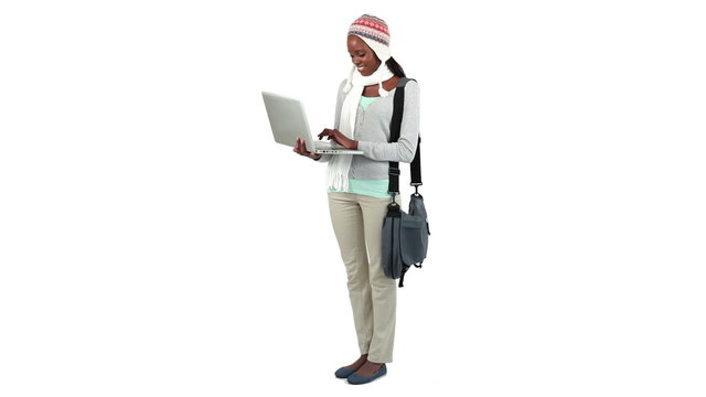 Woman holding and typing on a laptop