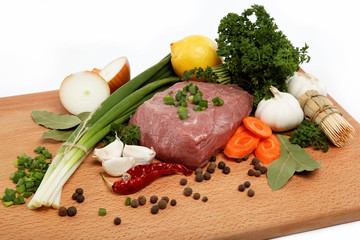 raw meat, vegetables and spices isolated on a wooden table.