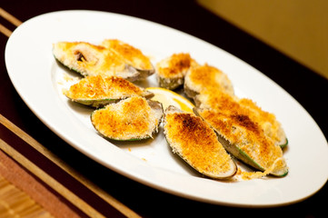 mussels under cheese with lemon
