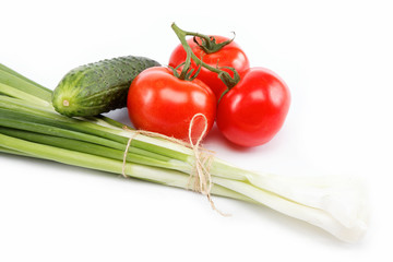 Fresh green onions, cucumber and tomato isolated on white.