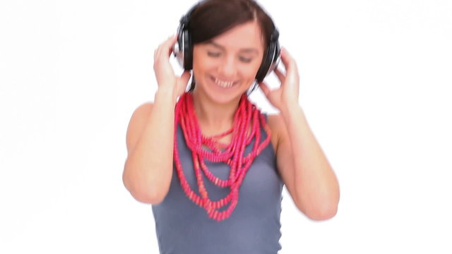 Woman dancing with her hands on her headphone