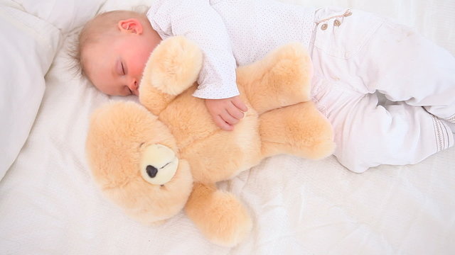 Baby sleeping with a teddy bear