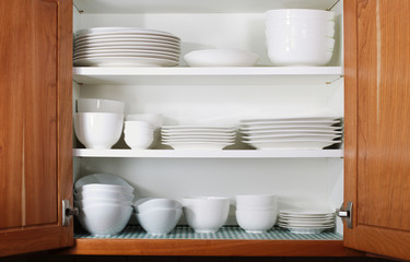 New White Dishes and Bowls in Kitchen Cabinet © tab62