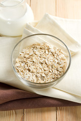 Oat flakes on a glass boel and jug of milk