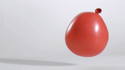 Red balloon rebounding in super slow motion - Powered by Adobe