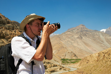 tourist with camera in mountains