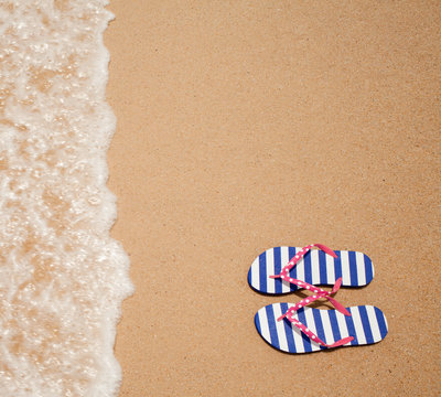 Colorful flipflop pair on sea beach top view