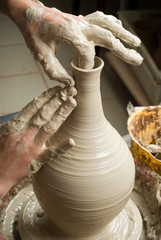hands of a potter, creating an earthen jar on the circle